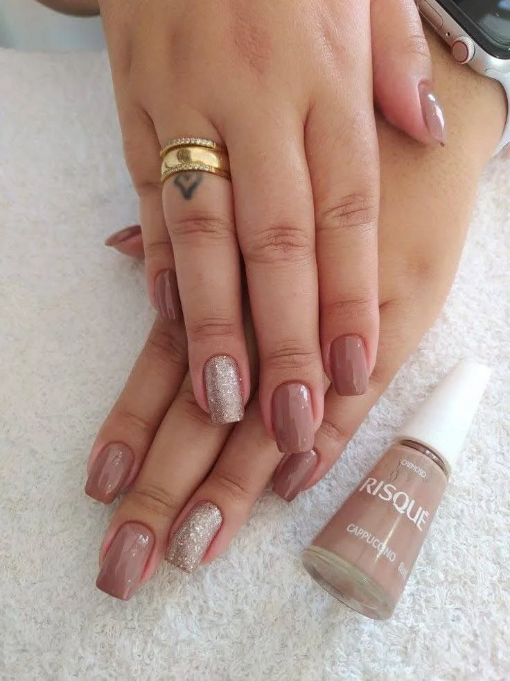 Short nails with lilac French tips, rhinestone accents, and a glitter accent nail, displaying a glamorous and chic style.