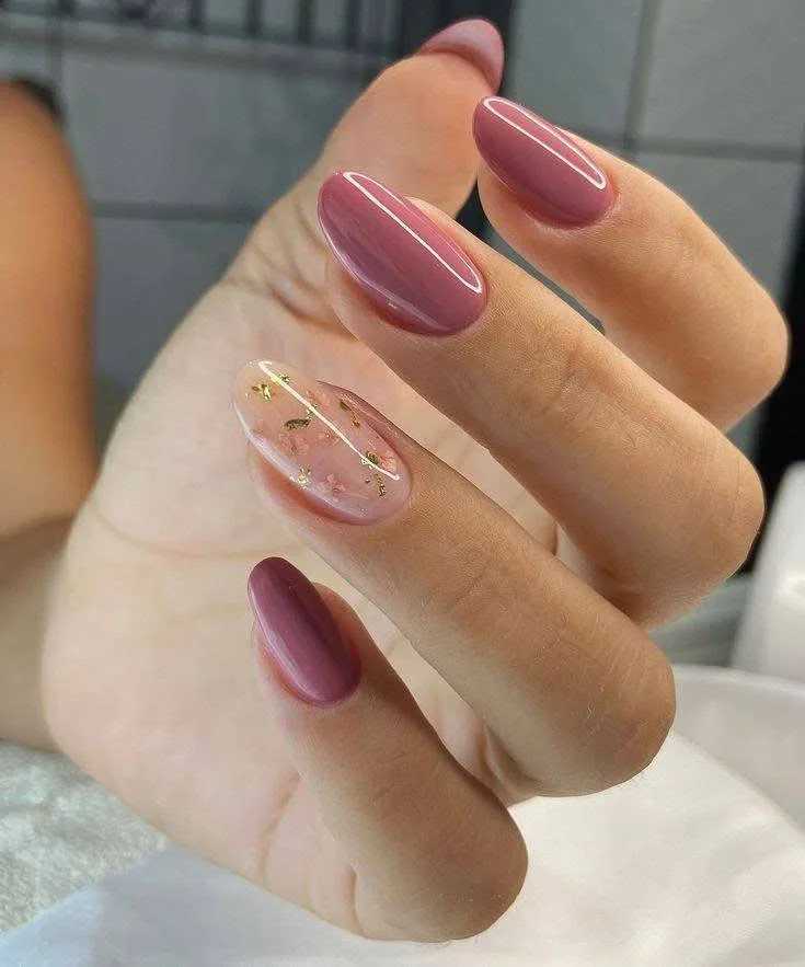 Short nails featuring deep red, soft pink, and a glitter accent nail with a heart detail, showcasing a glamorous Valentine's Day design.