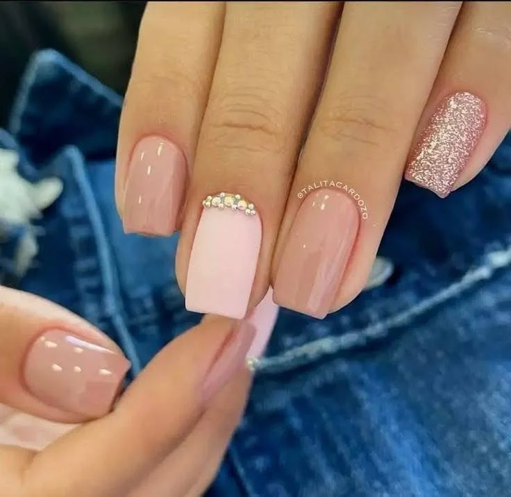 Short nails with red French tips and a small heart detail, displaying a glamorous and chic design.