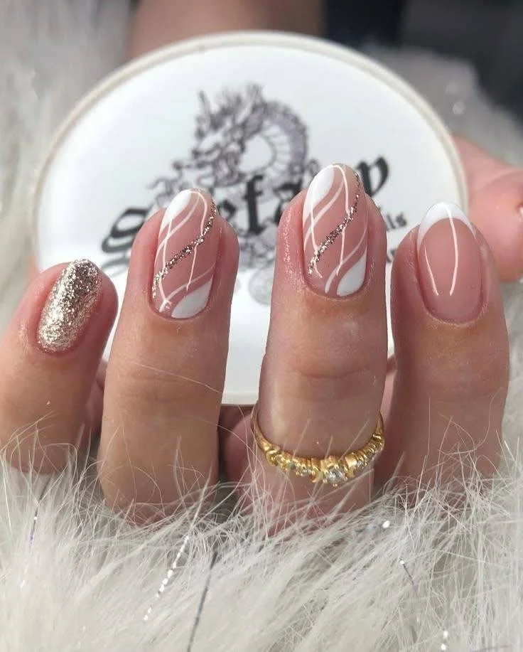 Short nails featuring a mix of designs including gold glitter, white accents, rhinestones, and a French tip, showcasing a glamorous and eclectic look.