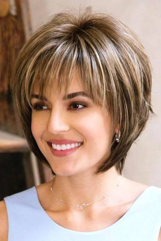 Feathered bob with bangs, a trendy and flirty short haircut option for 2025.