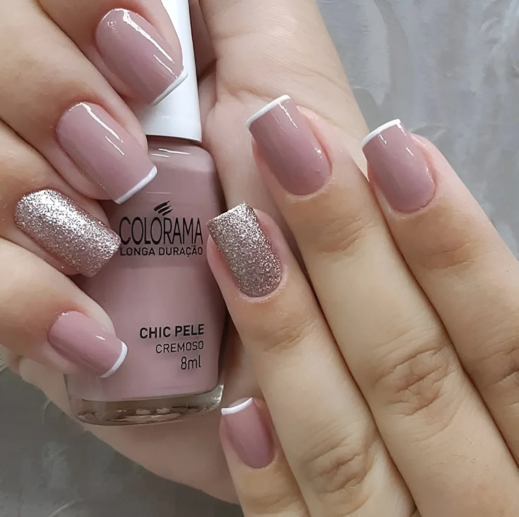 Short nude nails with white French tips and silver glitter accent nail.