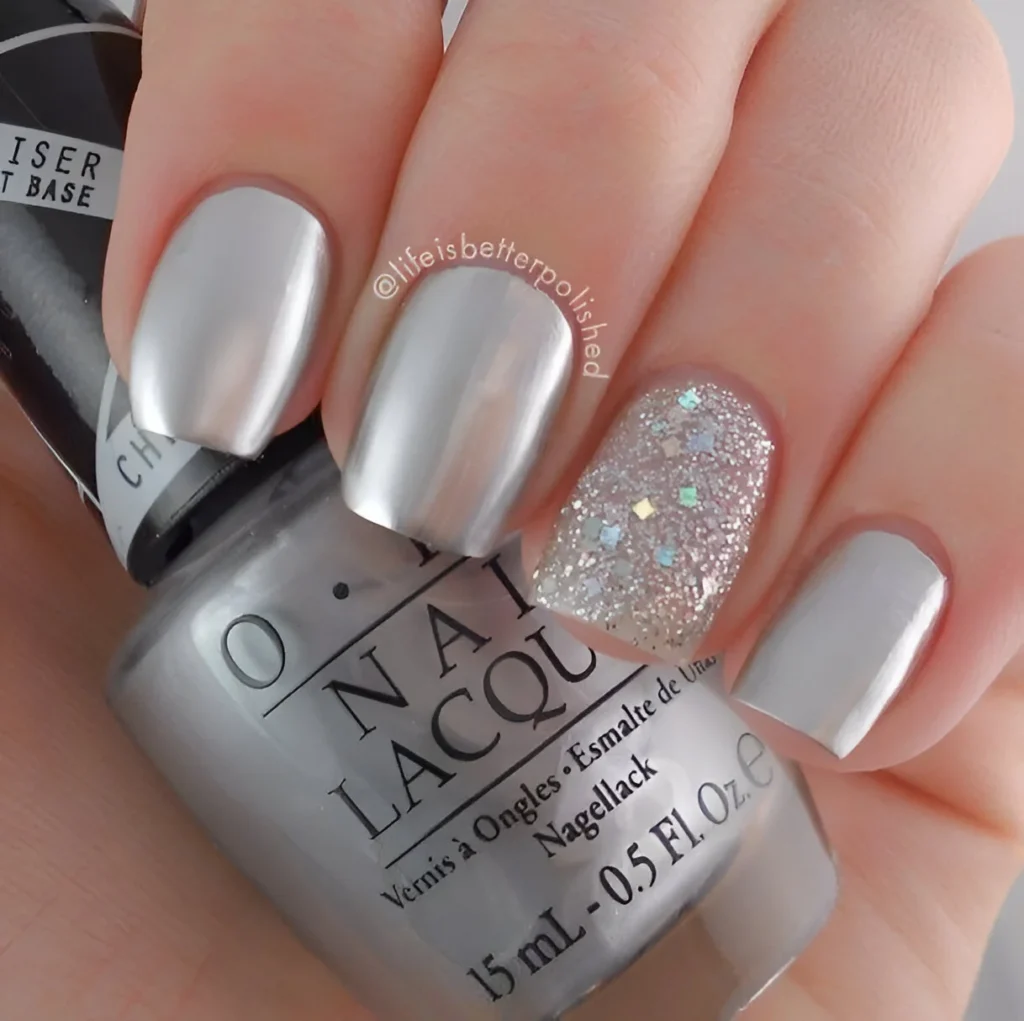 Short metallic silver nails with a multifaceted glitter accent nail.