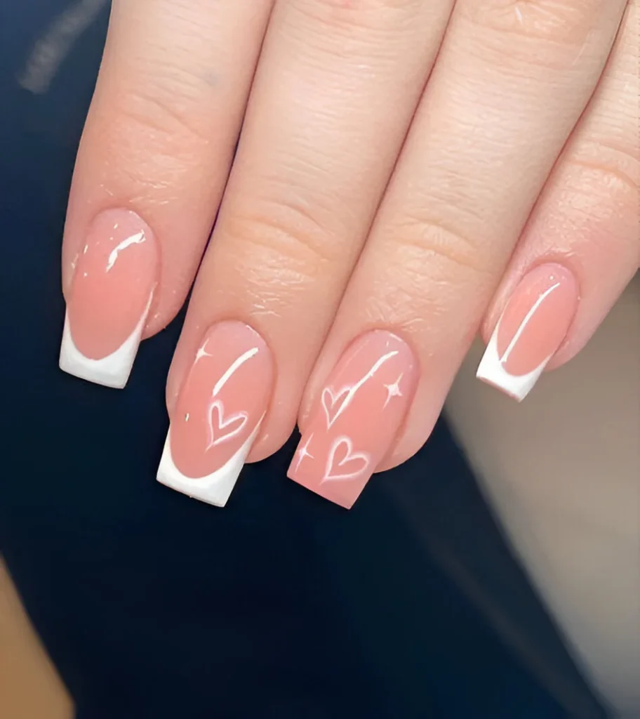 Simple nail designs with bold French tips and white heart outlines.