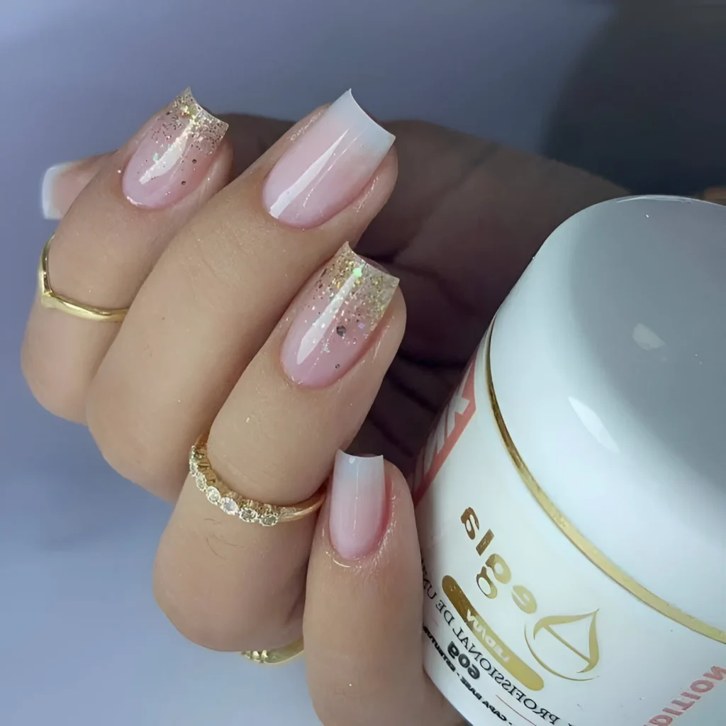 Simple nail designs with nude-pink ombre and gold glitter fade.