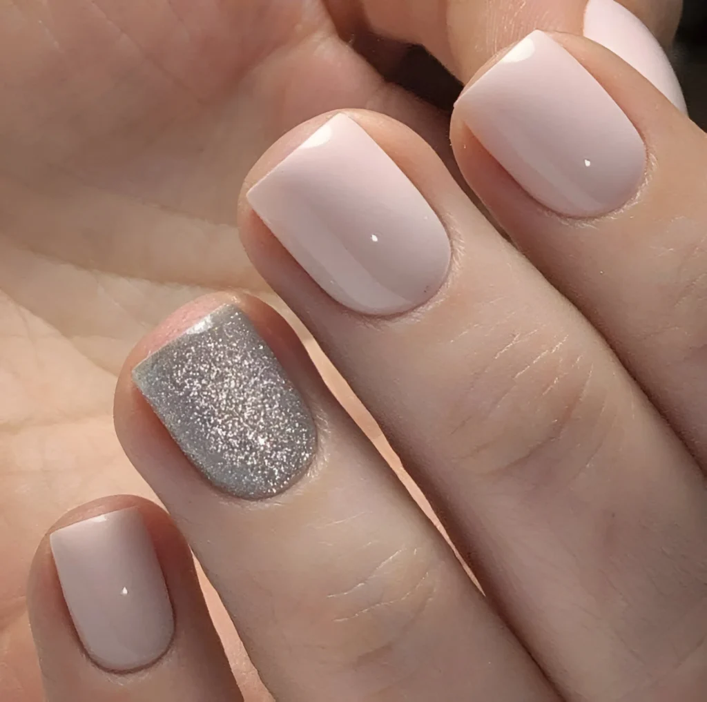 Simple nail designs with muted pink and full silver glitter accent.