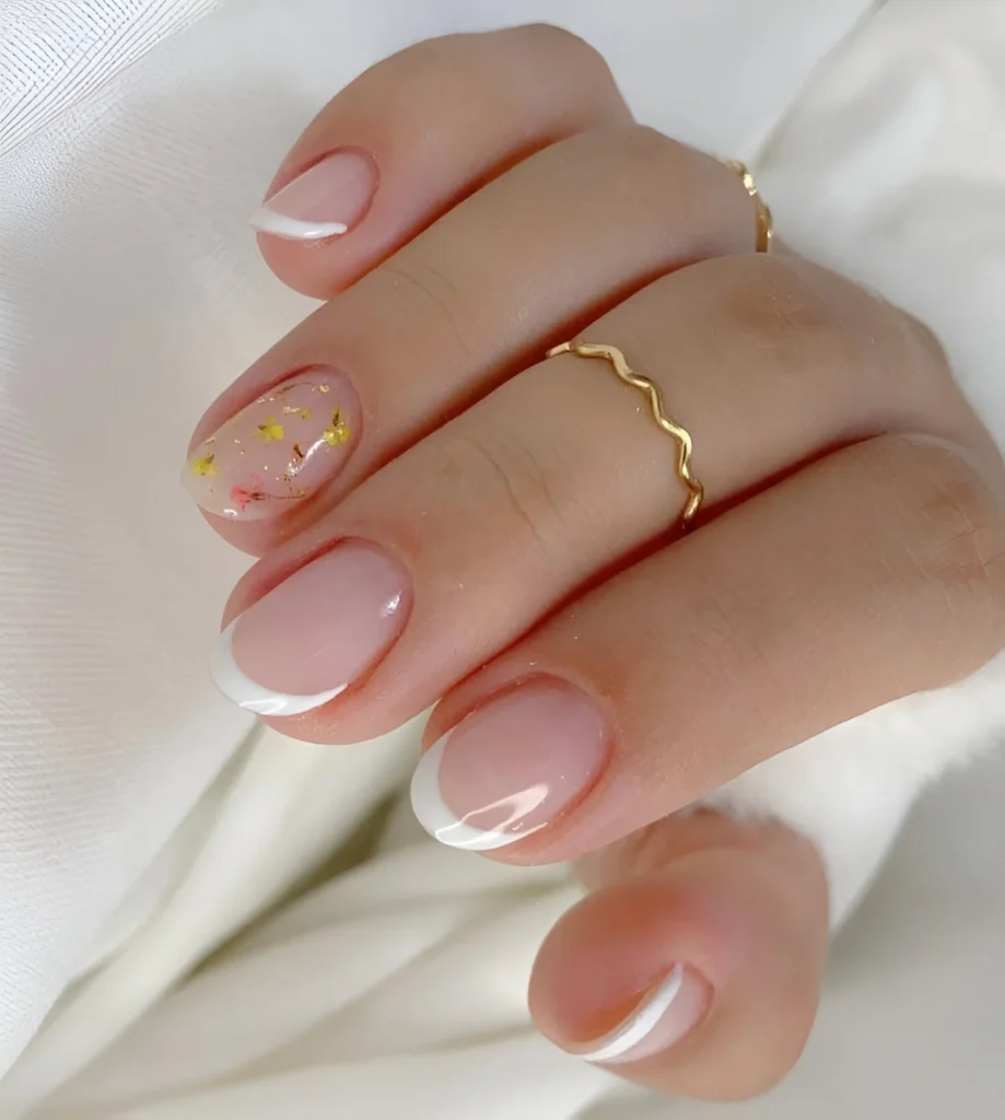 Shimmering French manicure with gold accents - elegant nail designs