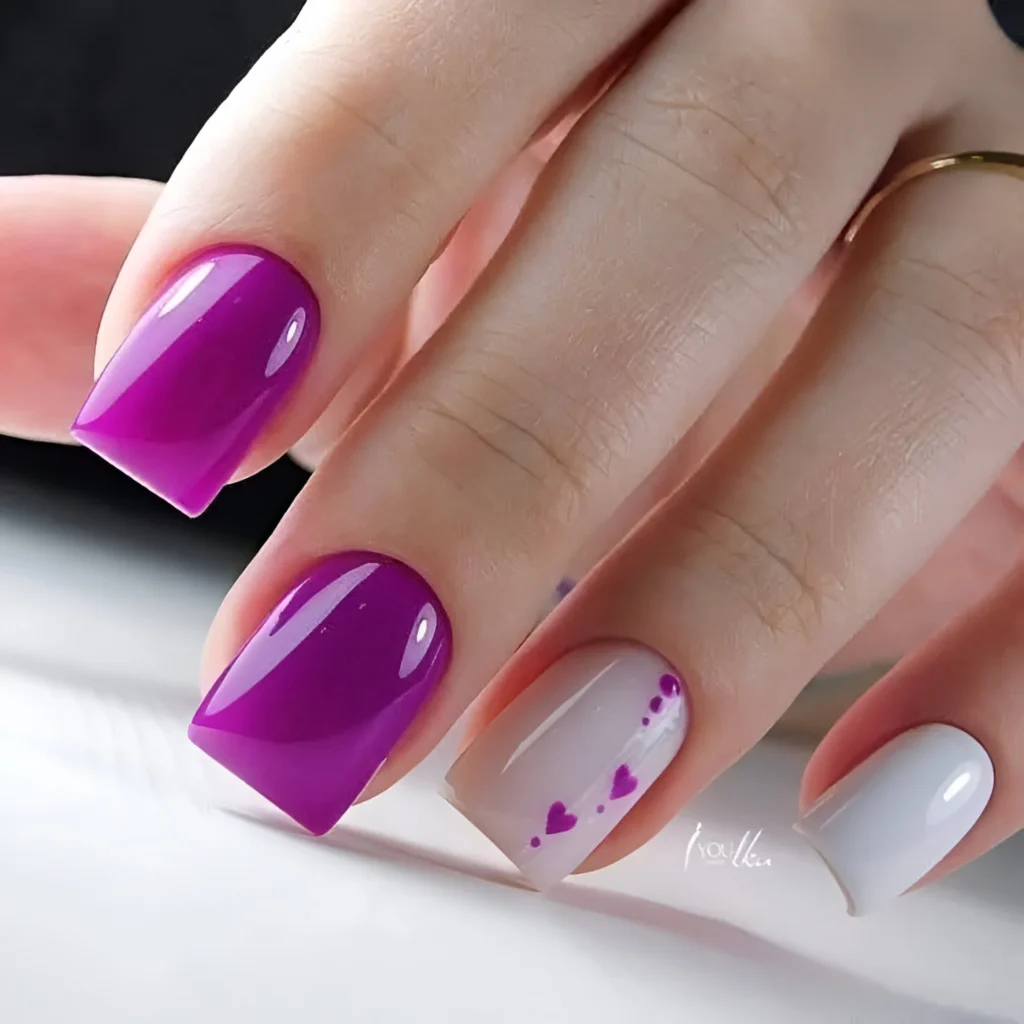 Purple and white nails with tiny heart accents.