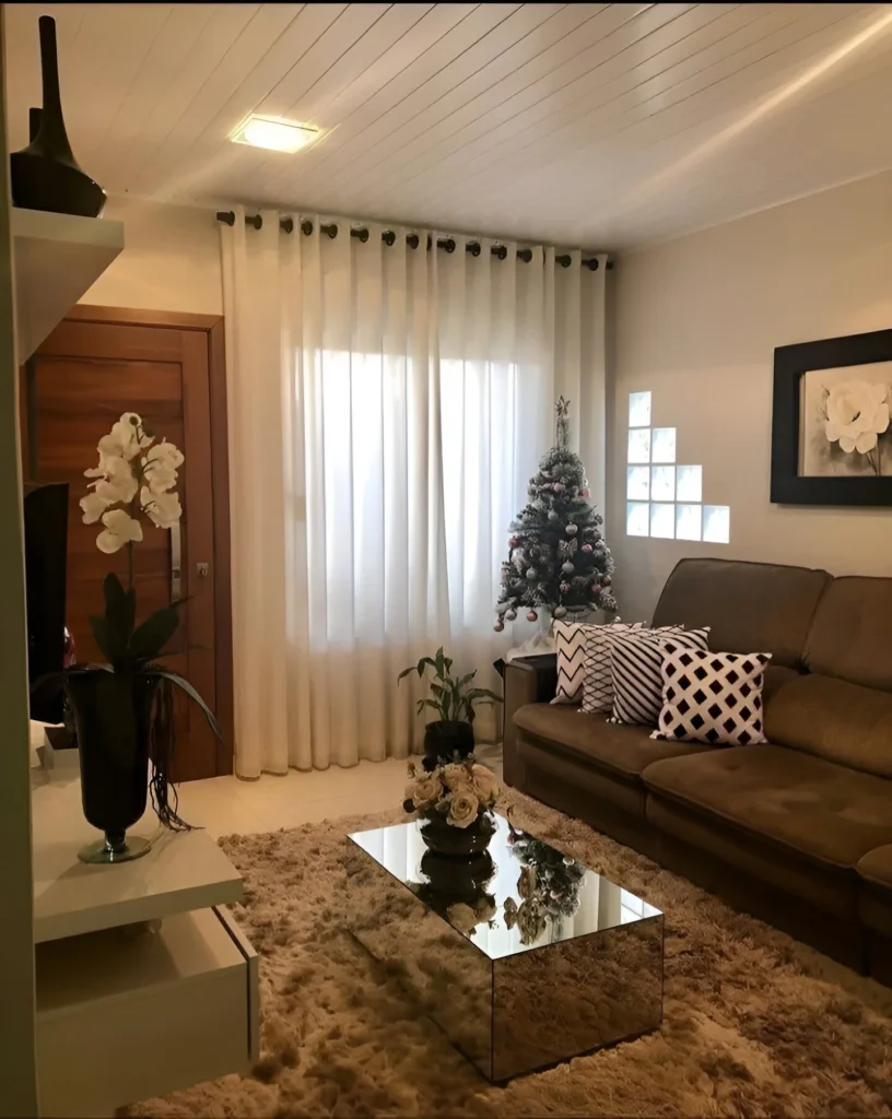 Cozy small living room with mirrored coffee table and festive decor.