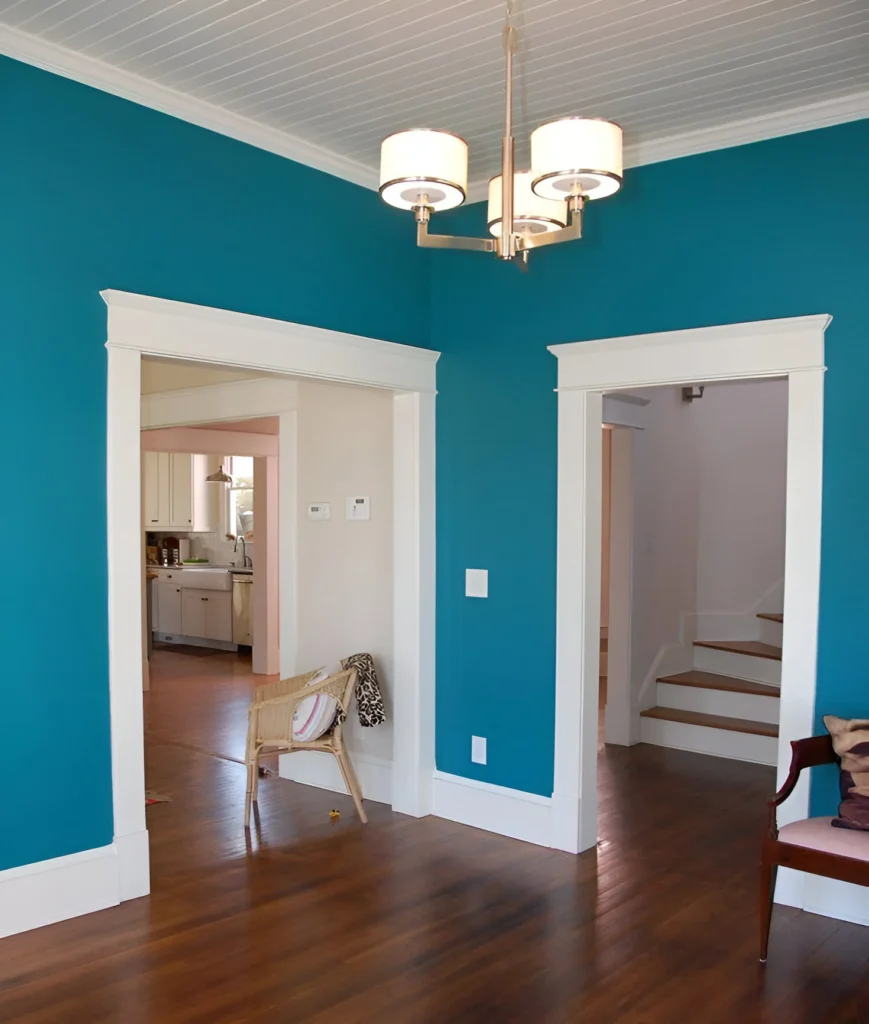 Bright turquoise accent wall with white trim.