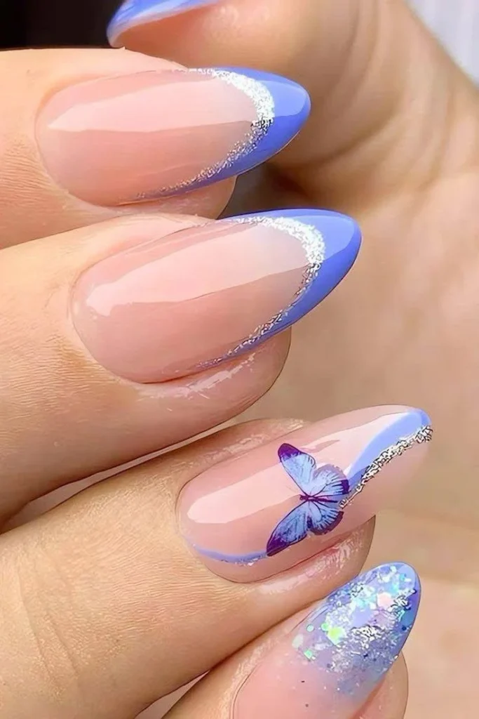 Blue butterfly nail art with periwinkle French tips and glitter.