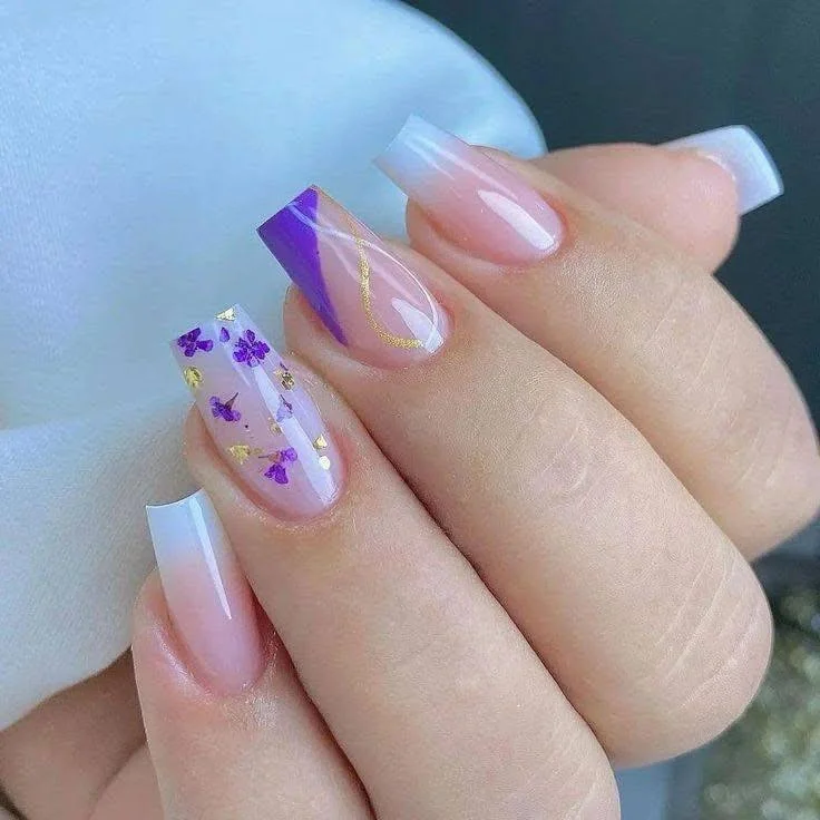 White French tip nails with purple, gold, and encapsulated flower accent nail. trendy nail designs