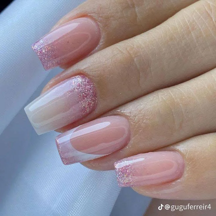 Feminine pink glitter French manicure with a nude base.