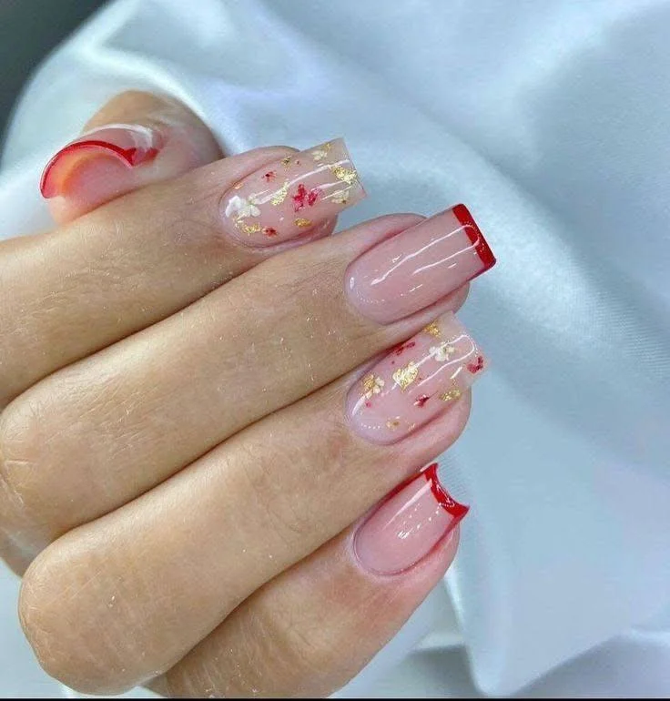 Red French tip nails with gold foil accents.