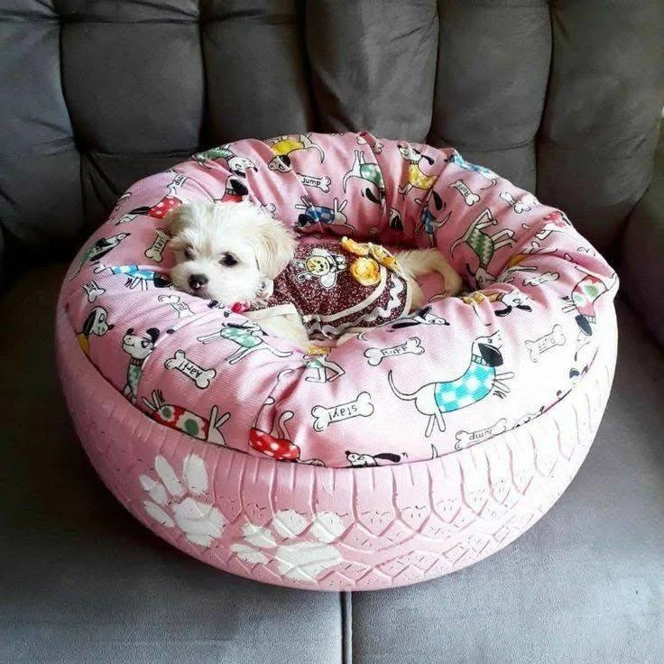 Man surrounded by several personalized upcycled tire pet beds, each with a different name and color. upcycling old tires