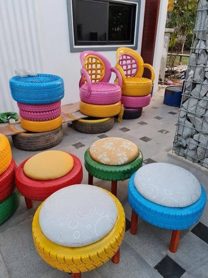 Four rope-wrapped upcycled tire ottomans with brown cushions, surrounding a glass-top tire table.