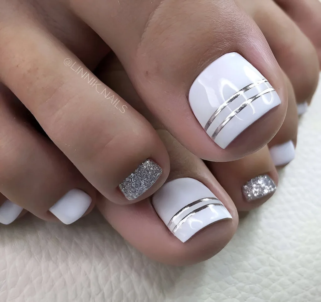 White toe nail designs with double silver stripe accents, modern pedicure.