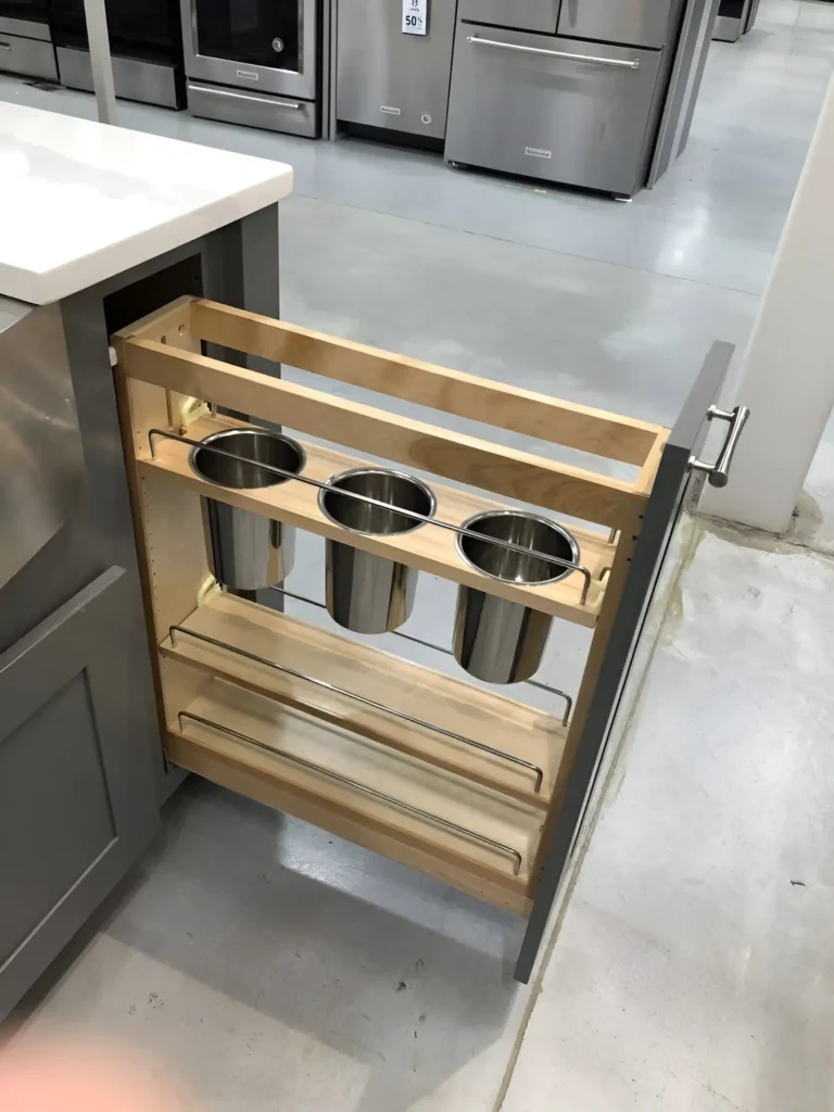 Pull-out utensil storage drawer within a kitchen island.