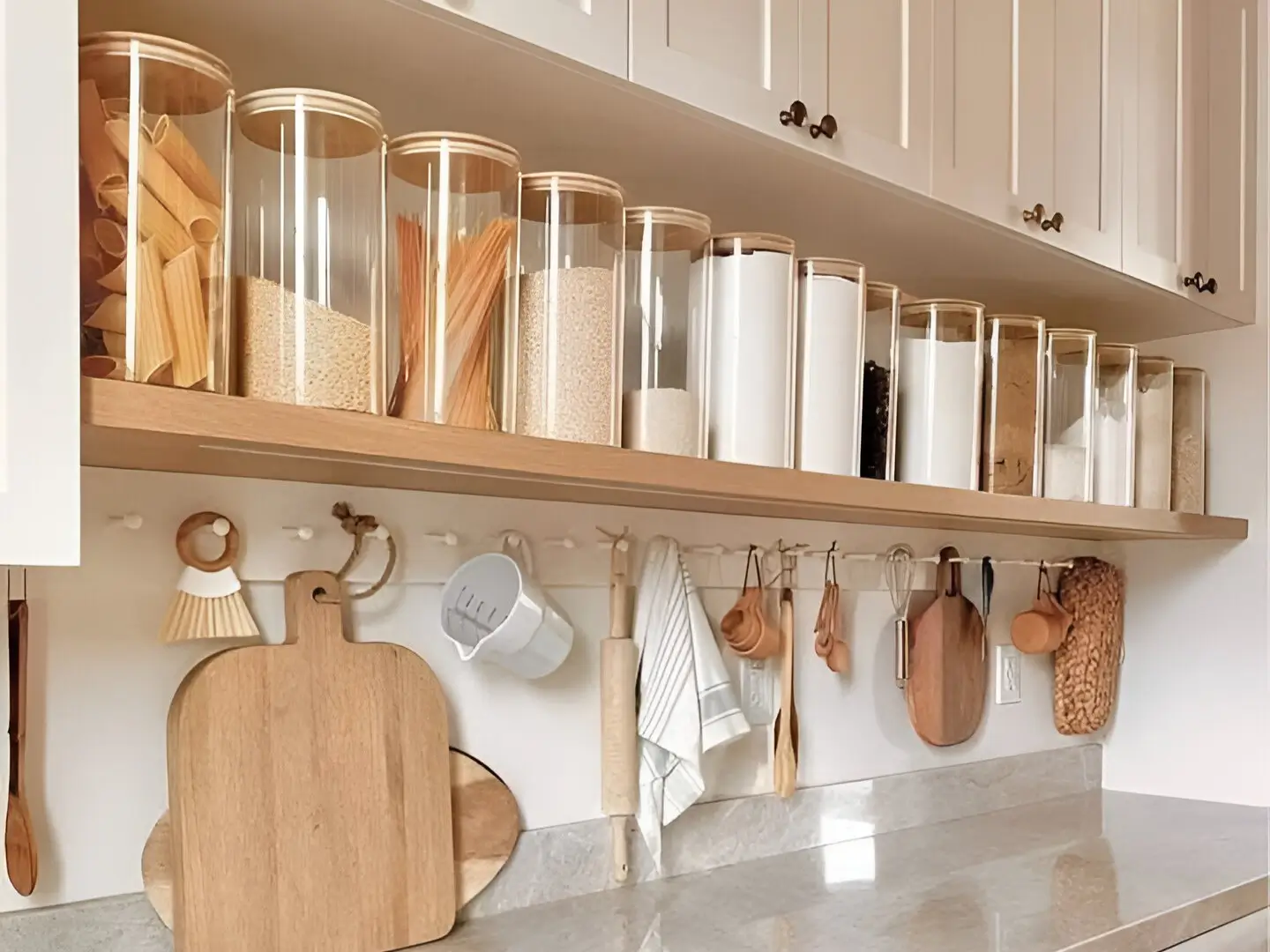 Kitchen countertop with open shelving displaying canisters and a hanging rail for utensils. Brilliant Home Organization Ideas to Maximize Space