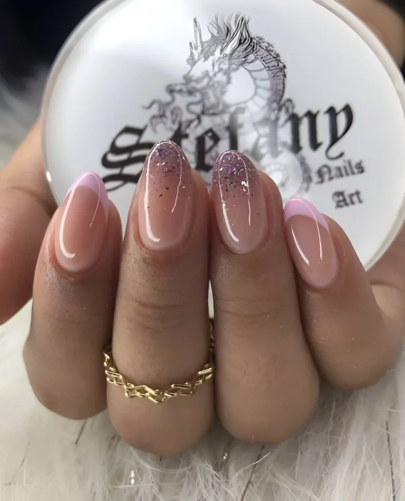 Almond-shaped nails. Two nails feature a classic French manicure design with a pale lavender tip instead of white. Two nails have a gradient effect, blending from clear at the base to lavender glitter at the tip.