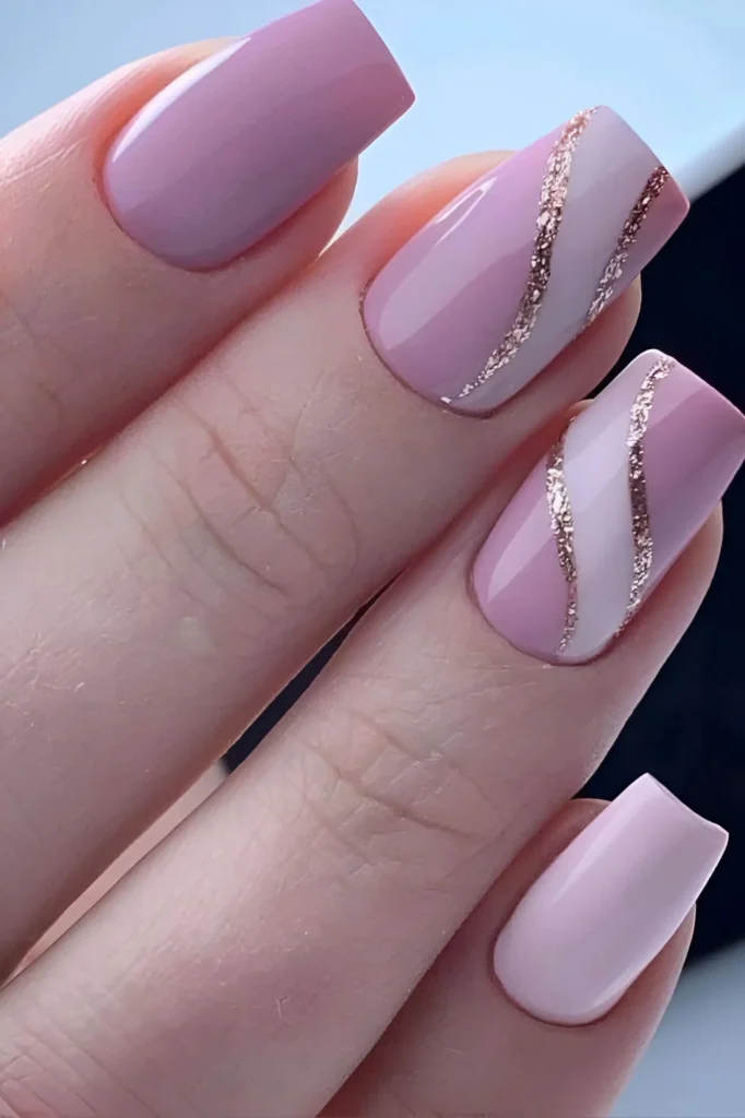 Square-shaped nails. Some are painted a solid, glossy rose in varying shades. Others feature a design with wavy, alternating stripes of pale pink and rose-gold glitter, creating a textured, striped effect.