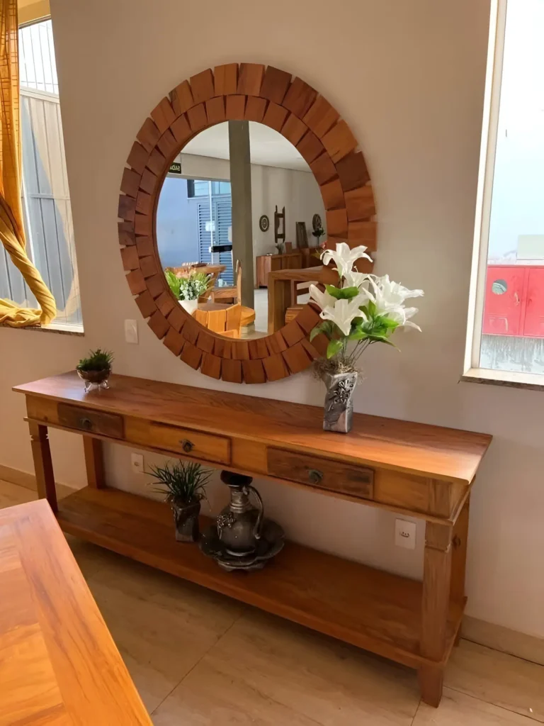 Wooden console table with a round statement mirror, decorative accents, and natural lighting.