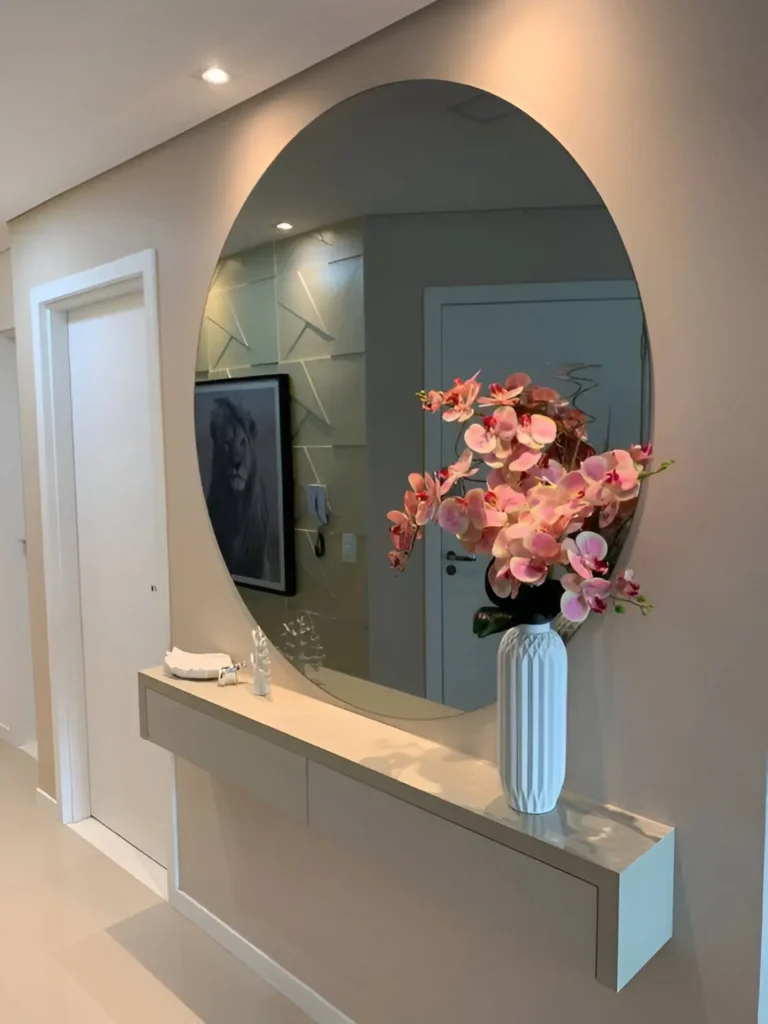 Modern entryway with a large round mirror, floating console, and floral decor.