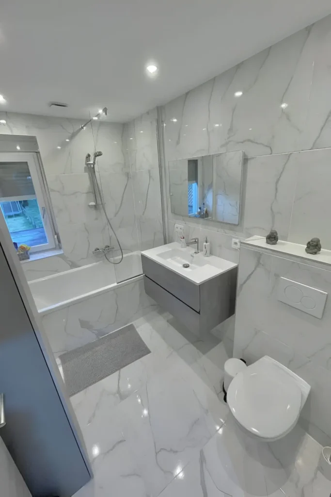 Luxurious marble bathroom with minimalist fixtures, soft lighting, and a modern design.