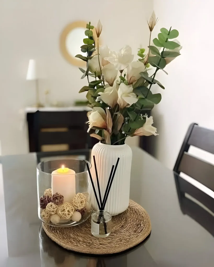 Elegant candlelit centerpiece with floral accents on a modern dining table.