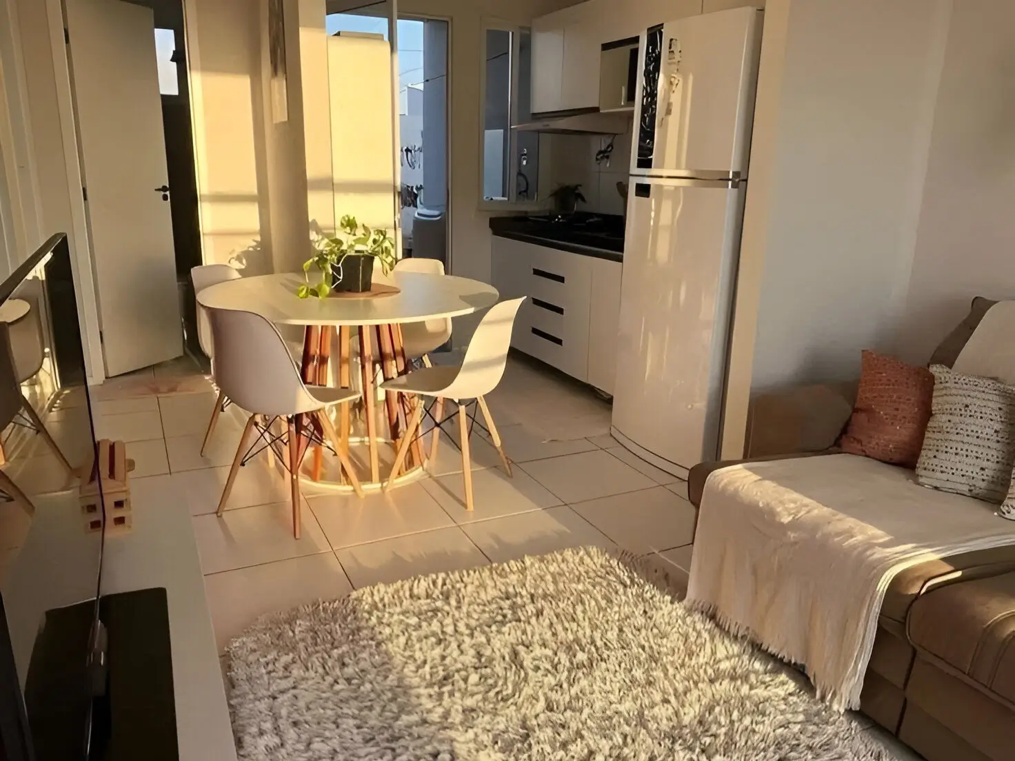 Small apartment with a round dining table, cozy seating, and natural sunlight creating an airy and inviting atmosphere. Interior Design Tips