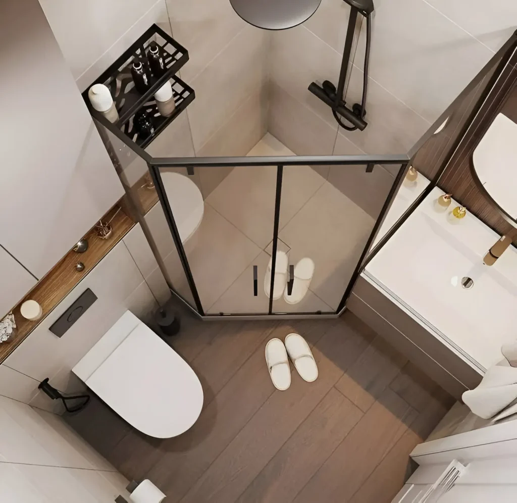 Overhead view of a small modern bathroom with a corner shower, floating toilet, and wood-look flooring.