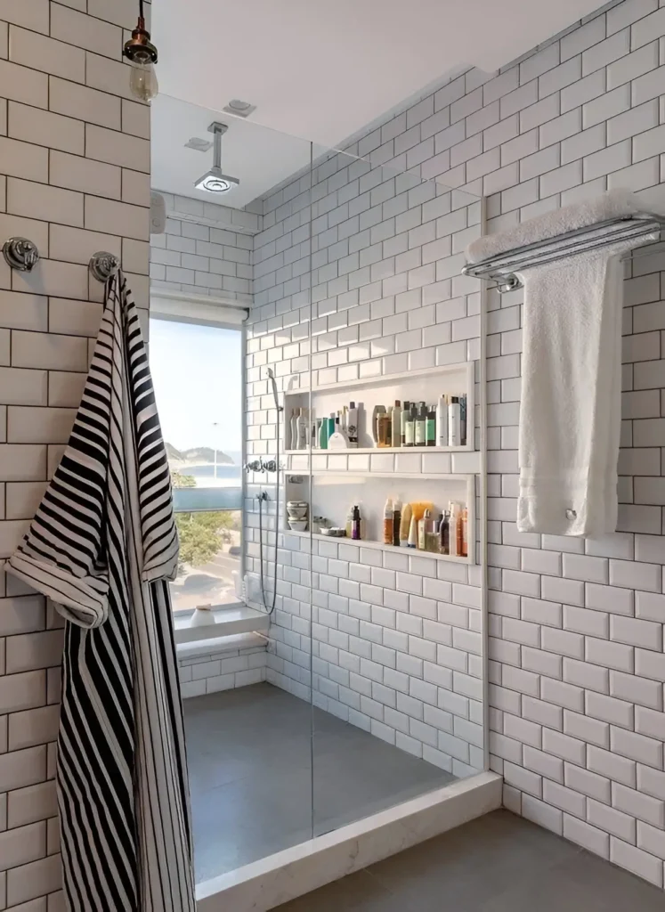 Modern small bathroom with white subway tile, built-in shower niche, and glass shower panel.