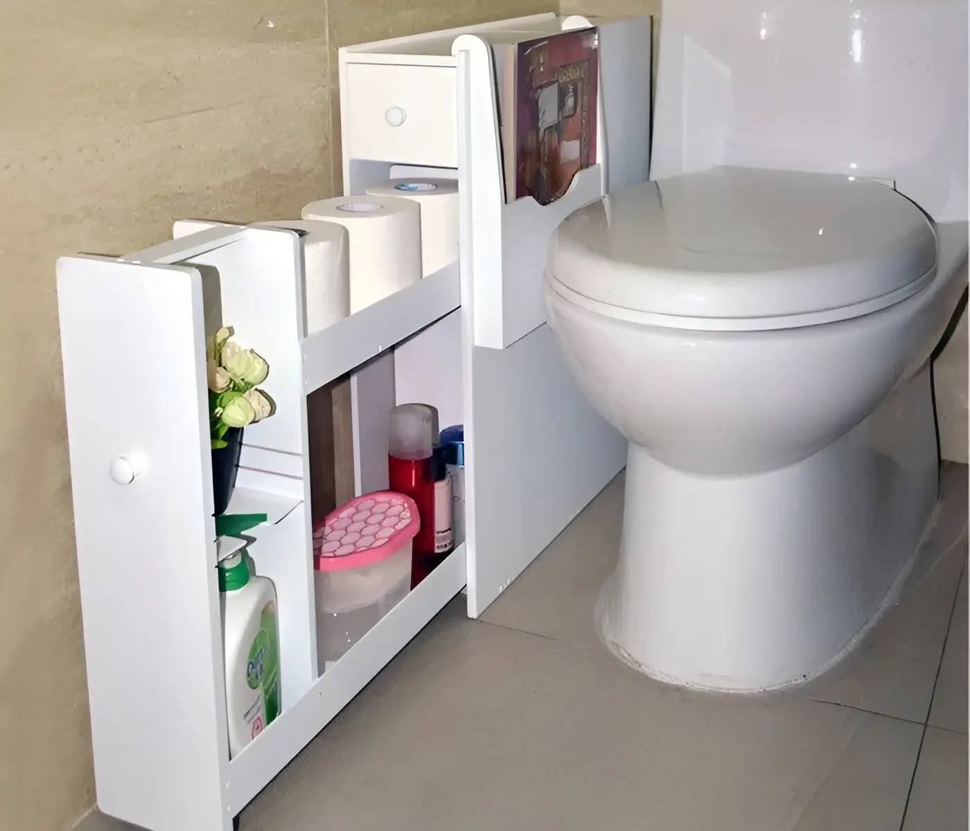 Slim white rolling cart with multiple shelves tucked beside a toilet, holding toilet paper, toiletries, cleaning supplies, and a small plant. Small Bathroom Storage Ideas