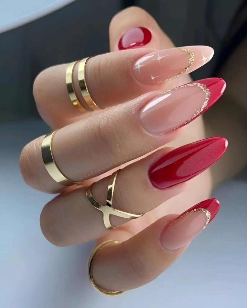 Glossy red and nude nails with delicate gold accents for a sophisticated finish.