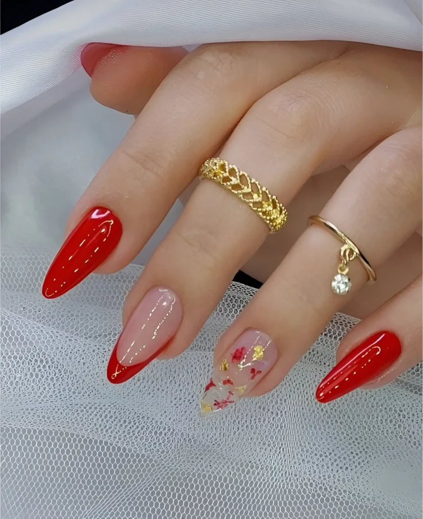 Red almond nails with floral and gold accents for an elegant and artistic touch.