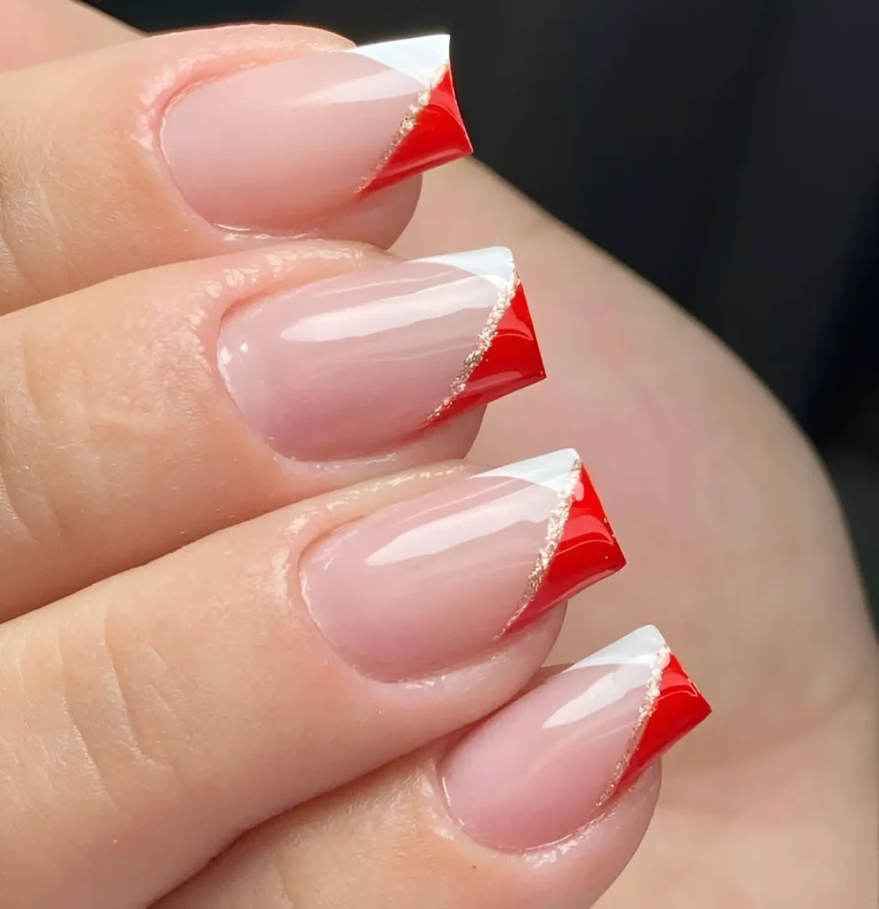 Red and white French tip nails with gold accents for a chic and modern look.