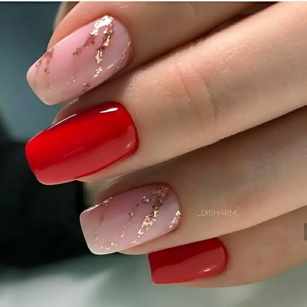 Ombre red and nude nails with gold foil details for an elegant and trendy design.