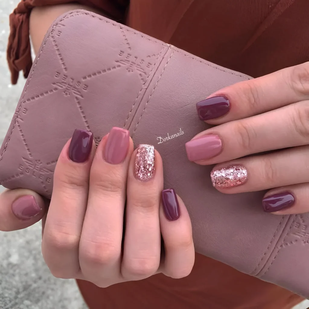 Elegant burgundy and dusty rose nails with rose gold glitter accent.