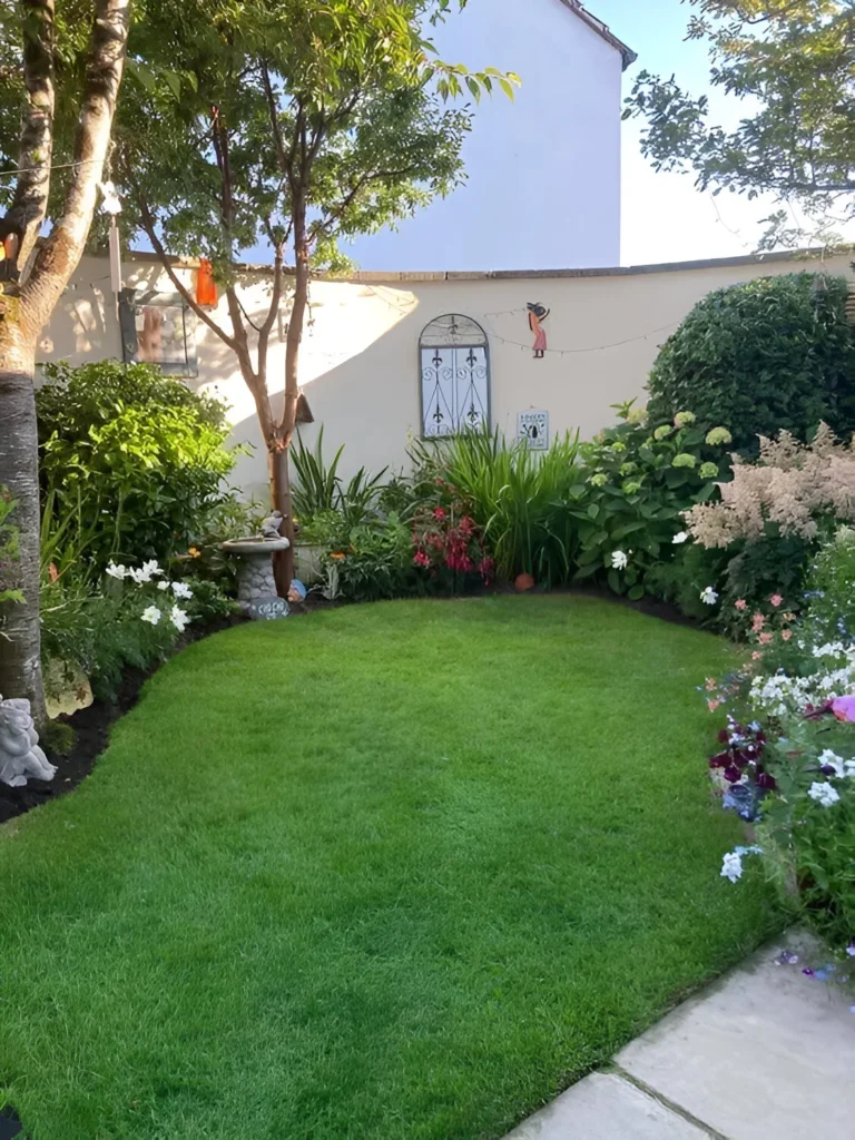 Garden decor with ornate elements adorning a wall, surrounded by plants.