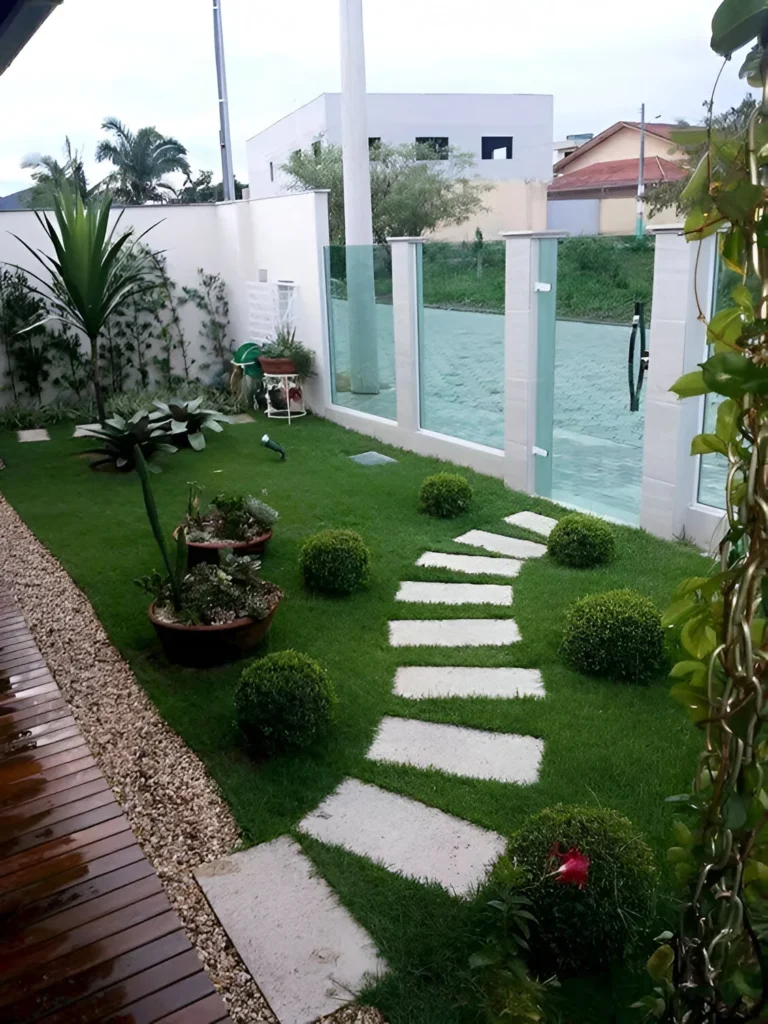 Garden decor with rectangular stepping stones set within a green lawn, surrounded by plants.