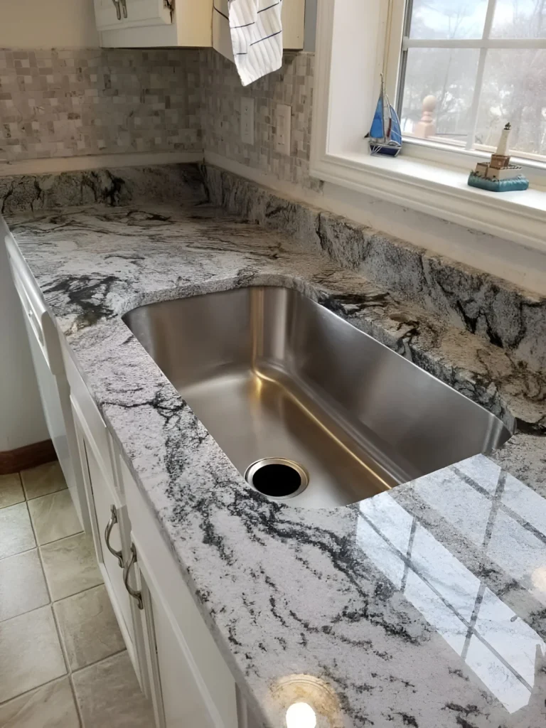 Undermount kitchen sink with granite countertop, showcasing a modern and clean design.