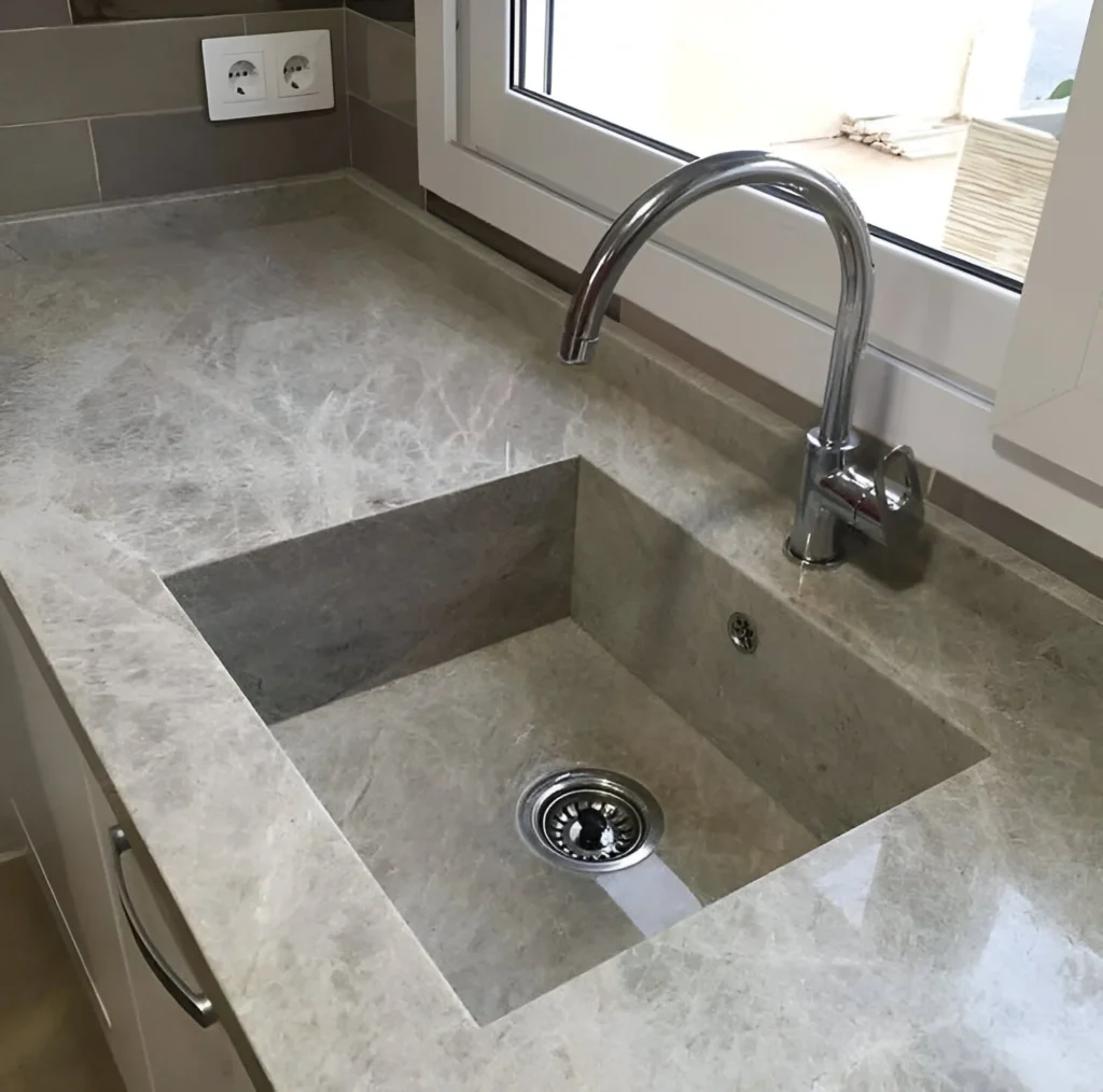 Integrated kitchen sink made of the same stone as the countertop, creating a seamless look.