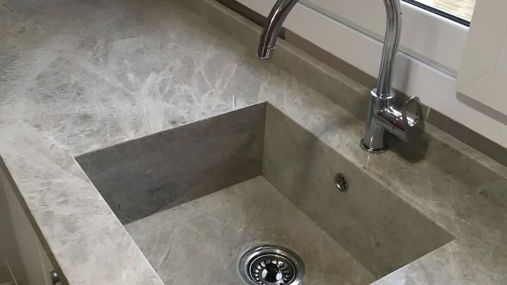 Integrated kitchen sink made of the same stone as the countertop, creating a seamless look.