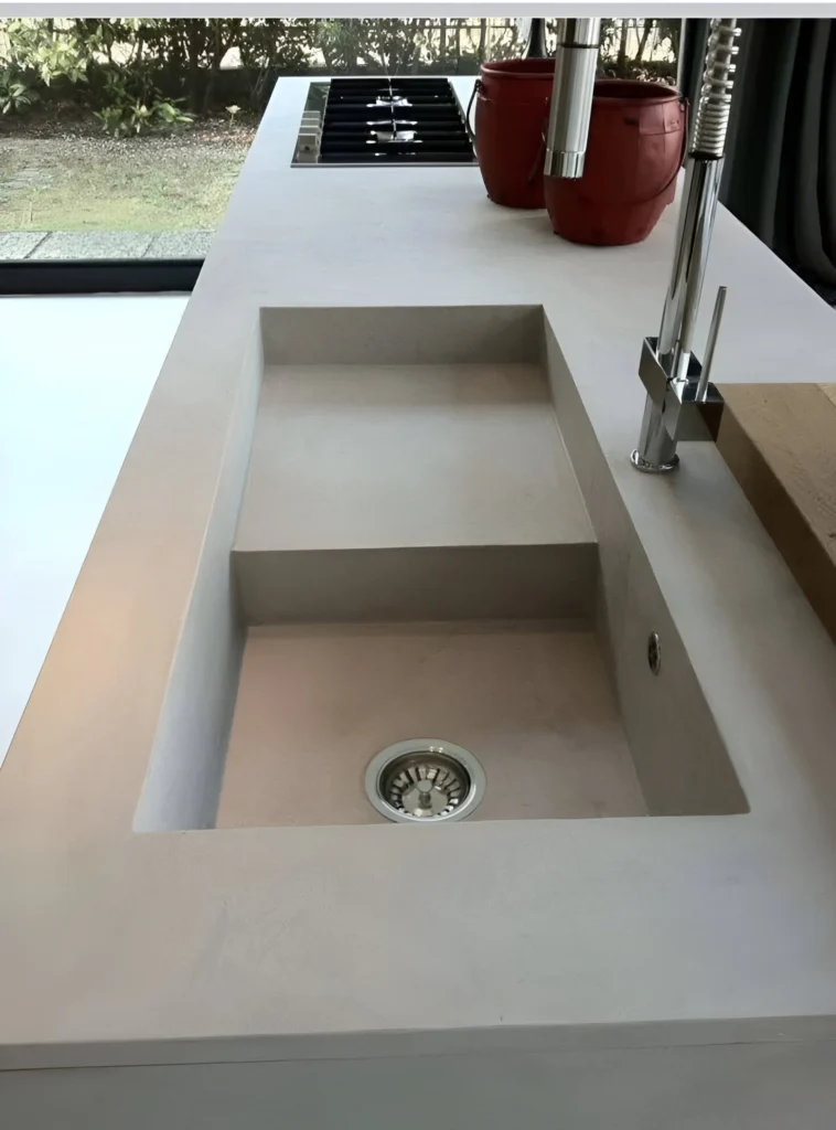 Concrete kitchen sink integrated into the countertop, showcasing a minimalist and modern design.