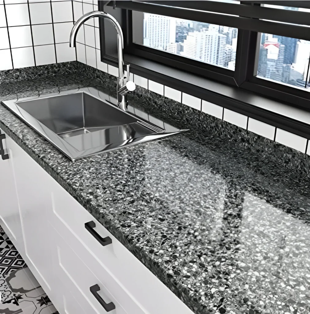 Modern kitchen sink with a single, deep stainless steel bowl and a dark, textured countertop.