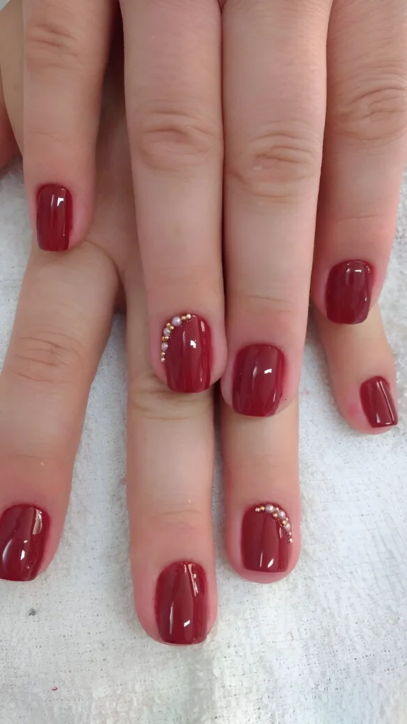 Wine red nails with pearl cuticle accents.