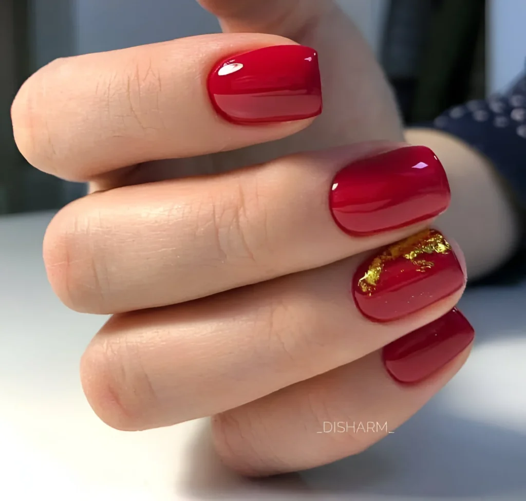 Classic red nails with gold leaf accent nail.