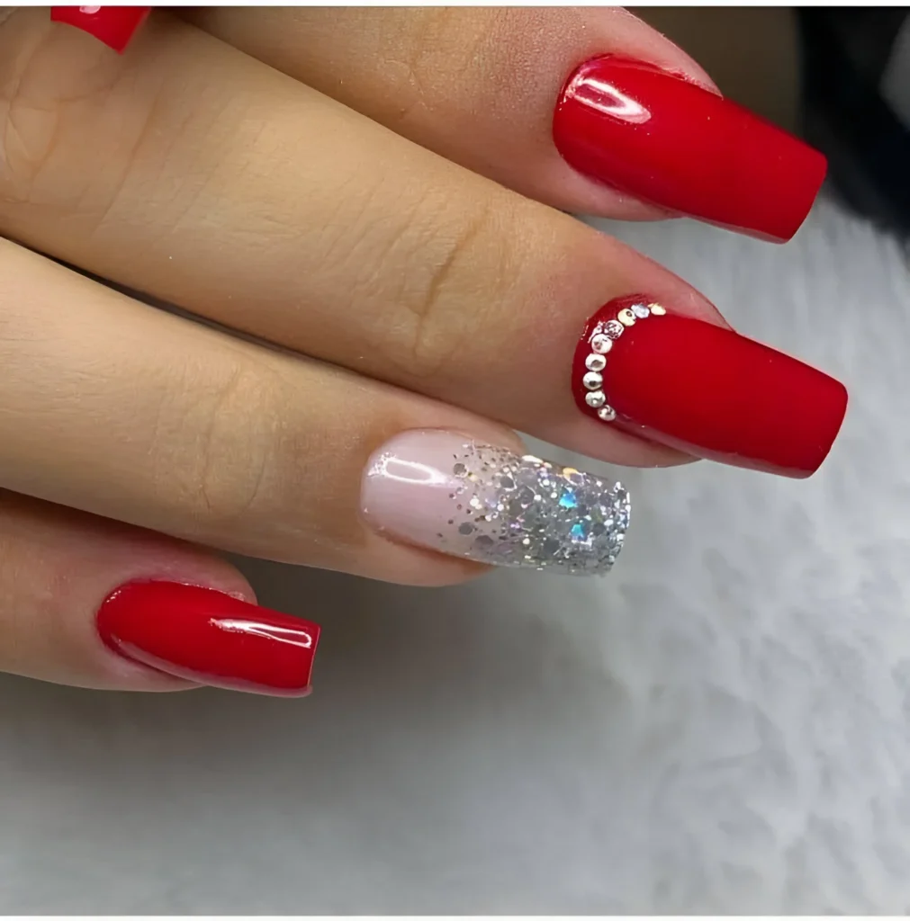 Stunning red and glitter nail design with rhinestones for a bold look.