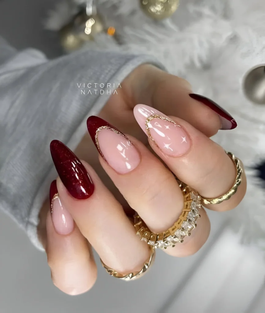 Burgundy and nude nails with gold accents for an elegant manicure.