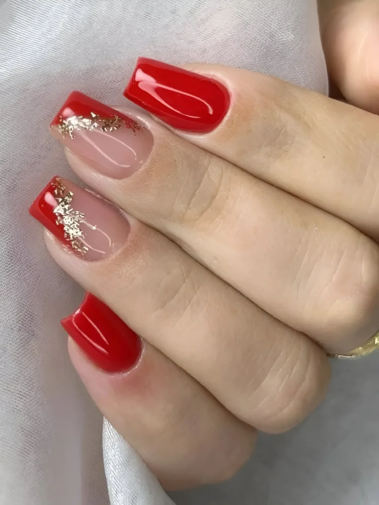 Glossy red nails with gold foil accents for a chic and elegant look.